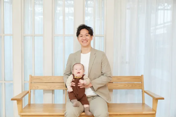 赤ちゃんを抱いて椅子に座る代表